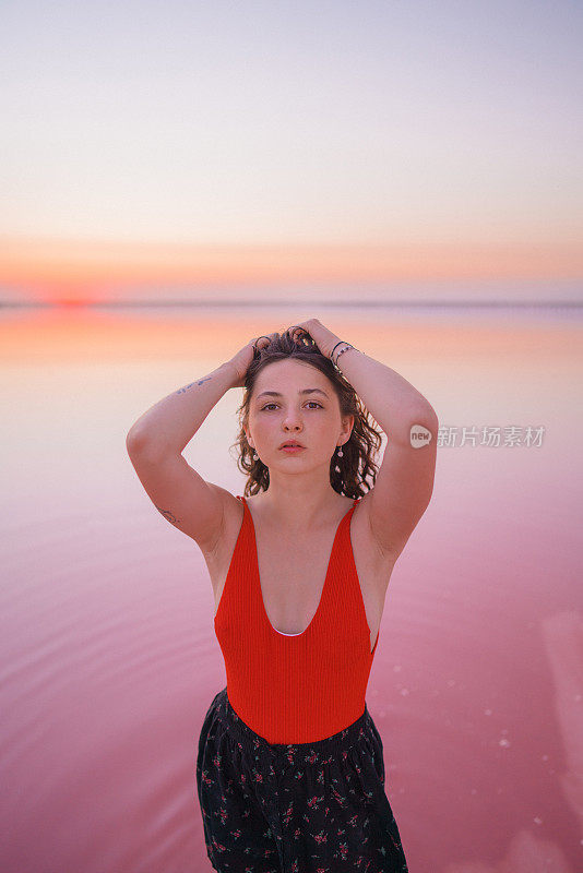 Woman walking  on pink salt lake in Ukraine